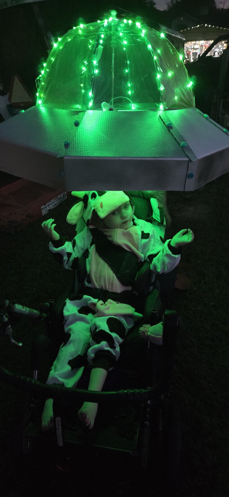 Child in a Cow Abducted by Aliens costume on wheels