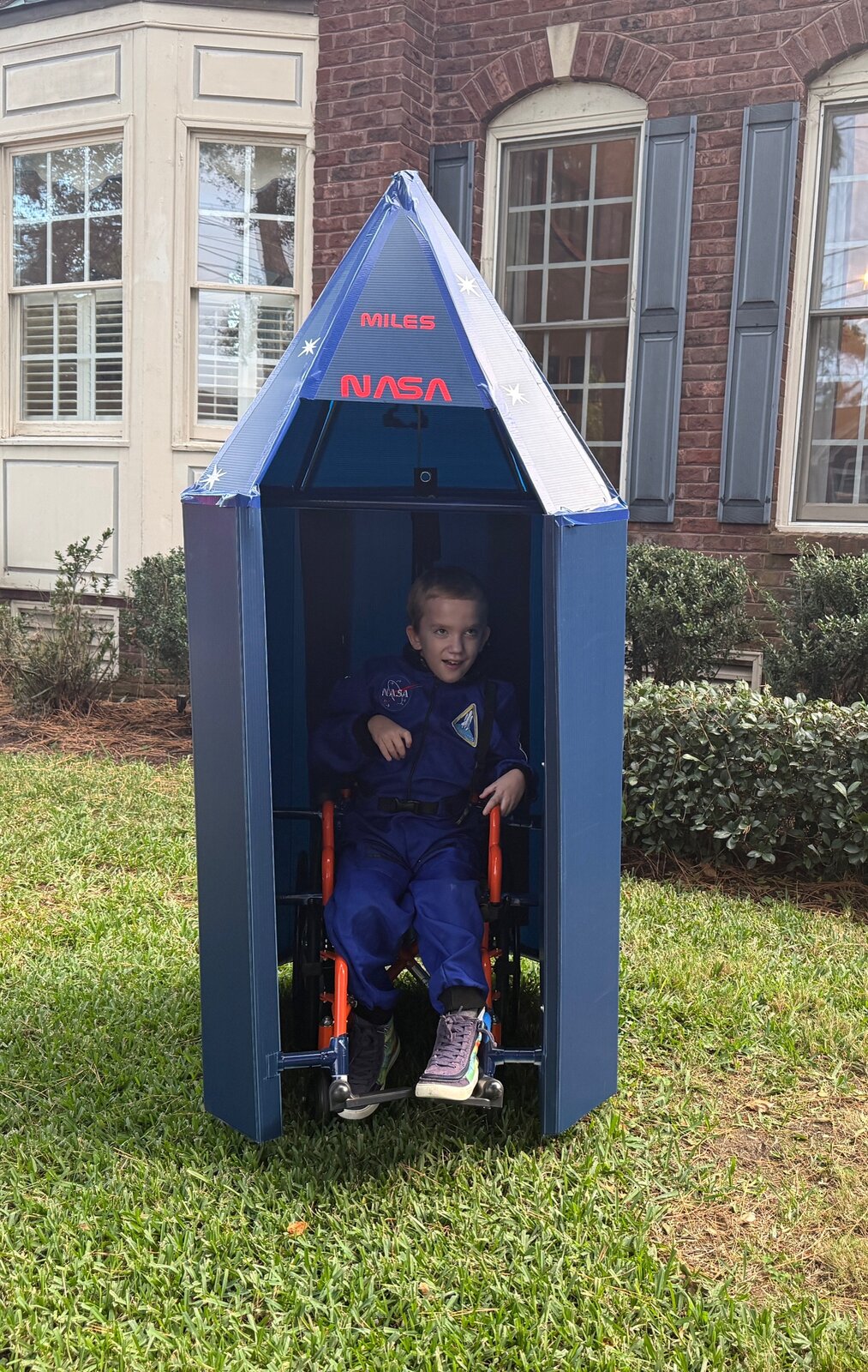 Child in a Dr. Ryland Grace astronaut costume inside a rocket ship on wheels