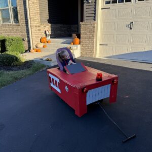 Child in a Firetruck costume on wheels