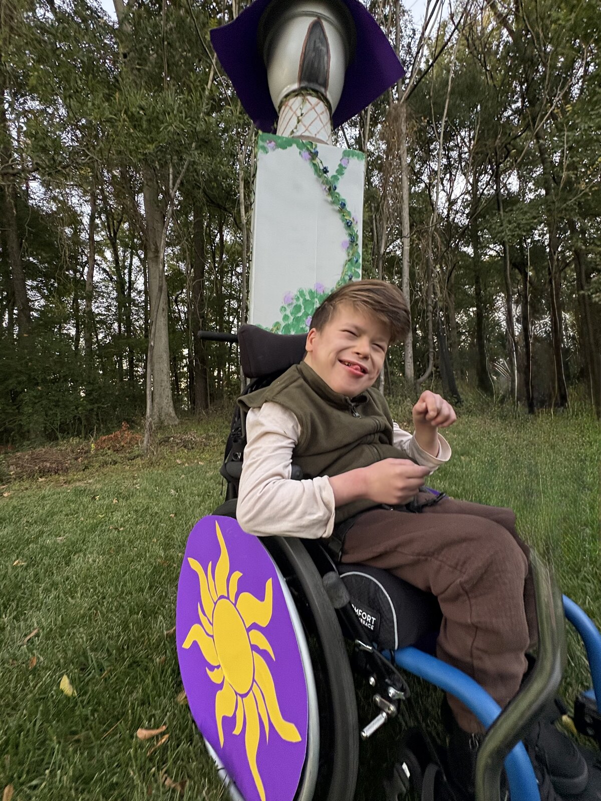 Child in a Flynn Rider with the Rapunzel Tower costume on wheels