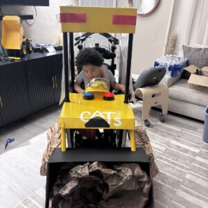 Child in a Built 2 Tough Construction Vehicle costume on wheels