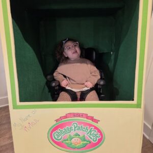 Child in a Cabbage Patch Doll costume on wheels