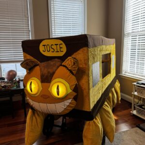 Child in a Catbus from My Neighbor Totoro costume on wheels