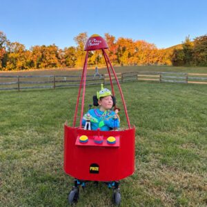 Child in a Claw Machine costume on wheels