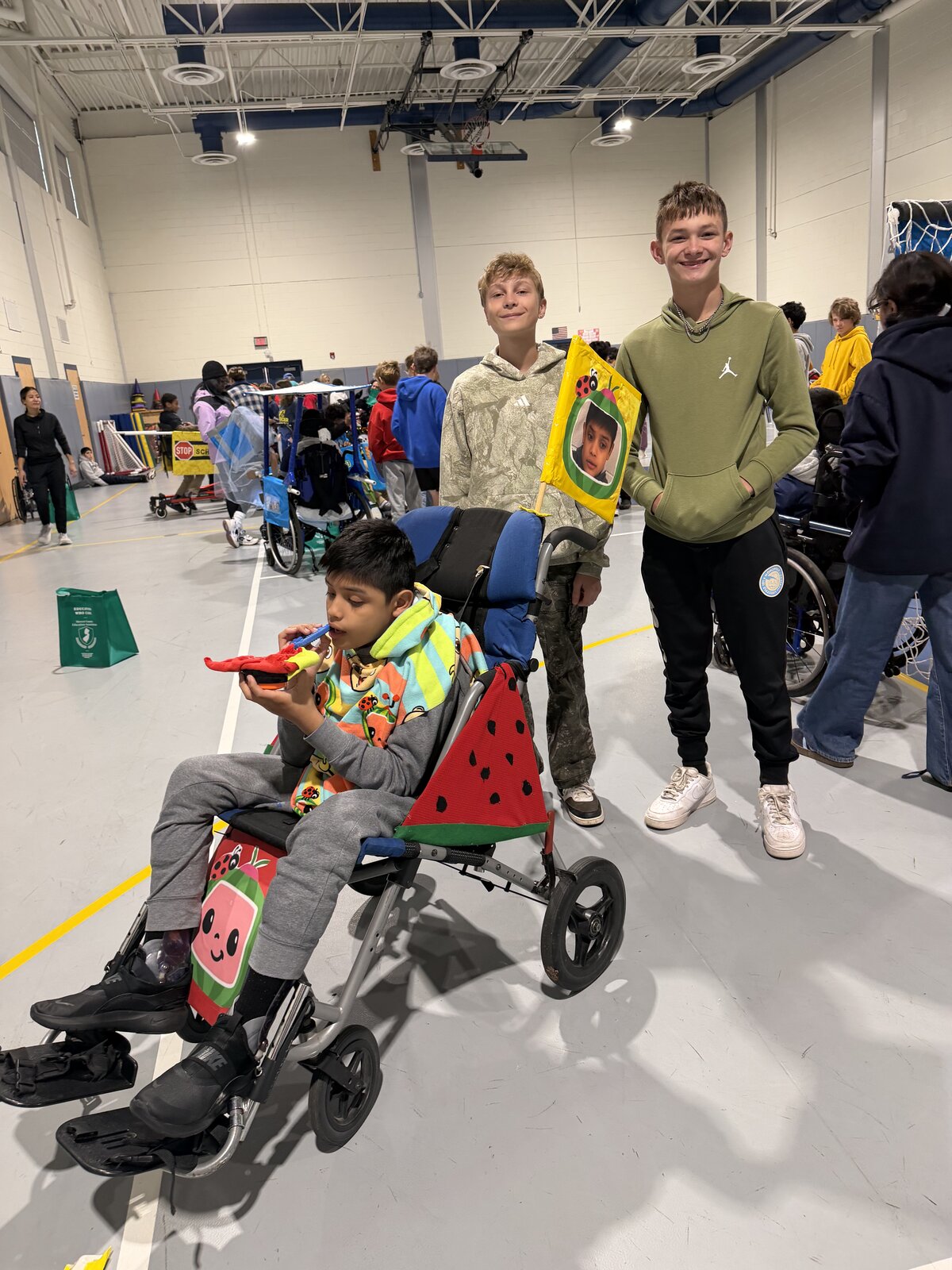 Child in a Cocomelon costume on wheels with the Timberlane Middle School students who built it