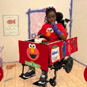 Child in an Elmo's World costume on wheels