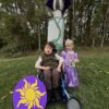 Child in a Flynn Rider with the Rapunzel Tower costume on wheels