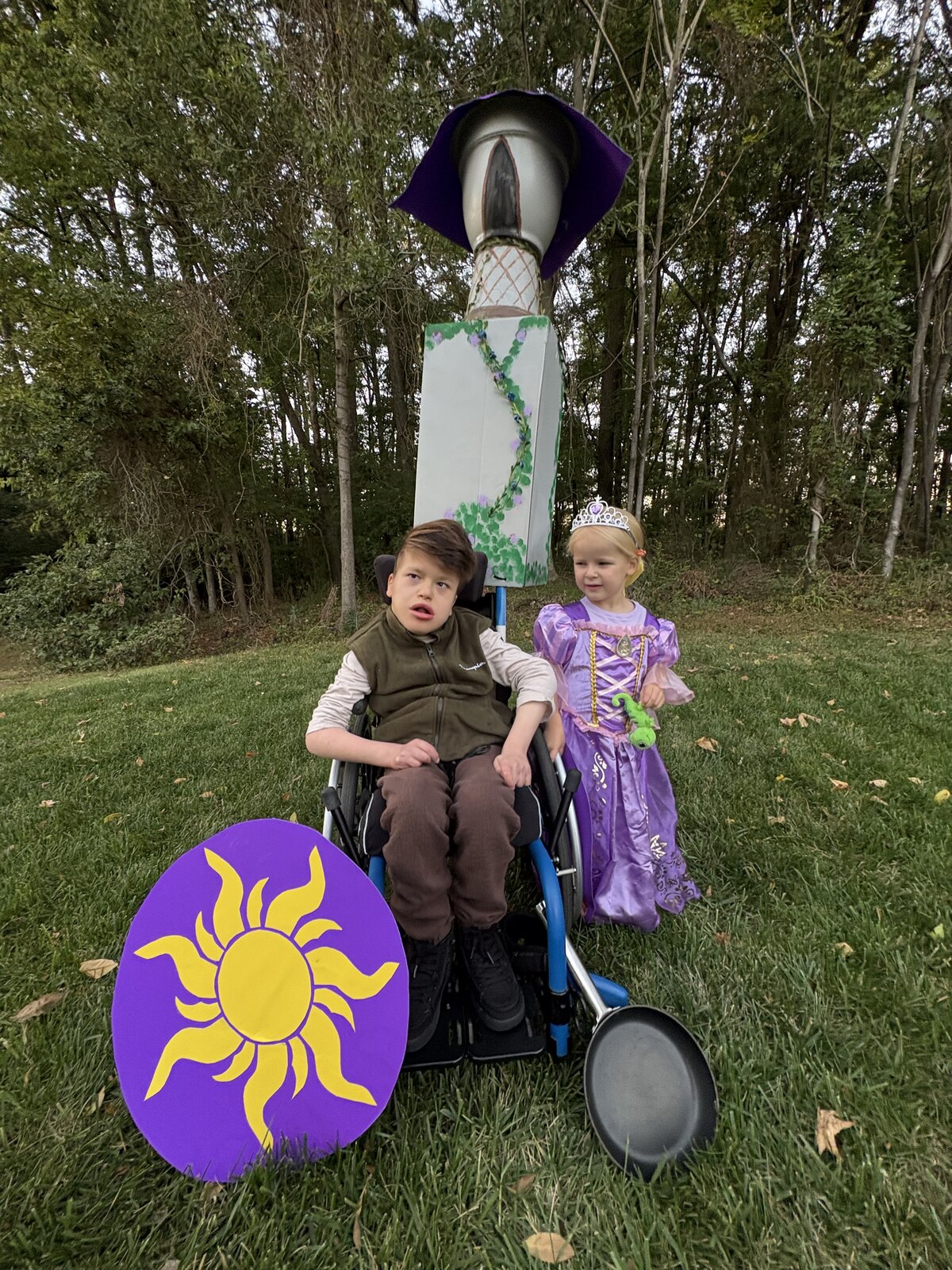 Child in a Flynn Rider with the Rapunzel Tower costume on wheels
