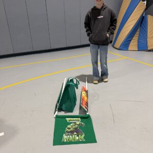 Child in an Incredible Hulk costume on wheels with the Timberlane Middle School students who built it