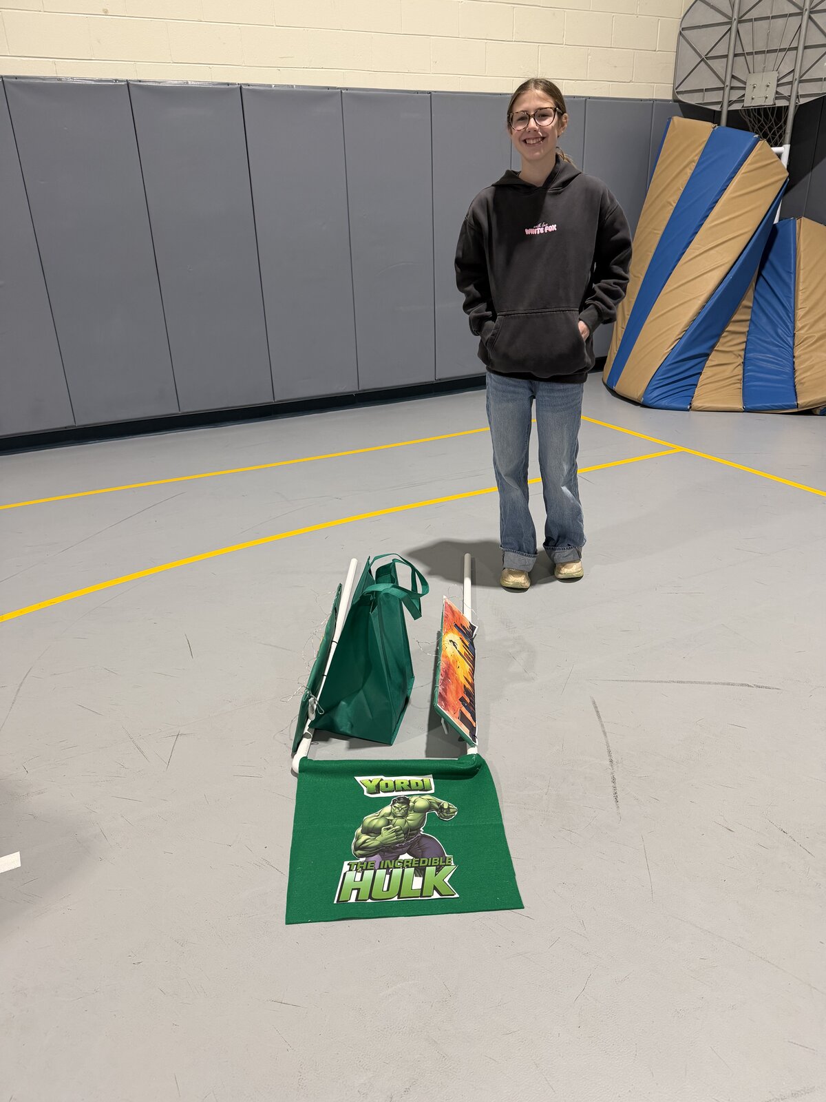 Child in an Incredible Hulk costume on wheels with the Timberlane Middle School students who built it