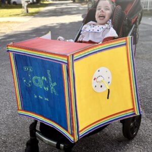 Child in a Jack in the Box costume on wheels