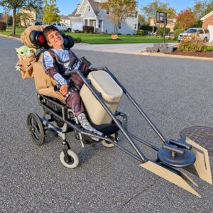 Child in a Mandalorian and Grogu costume on wheels