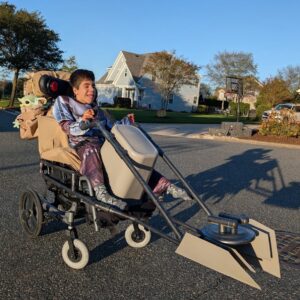 Child in a Mandalorian and Grogu costume on wheels