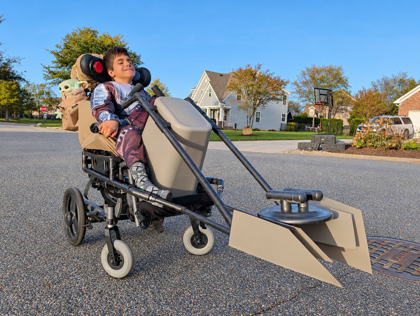 Child in a Mandalorian and Grogu costume on wheels