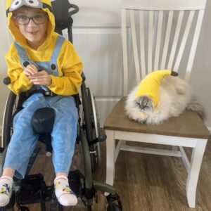 Child in a Minion costume with his favorite food, a banana, on wheels