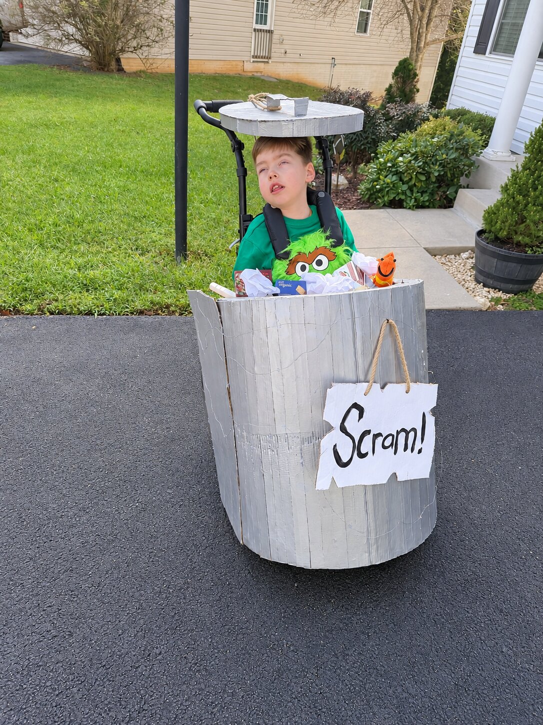 Child in an Oscar the Grouch and Elmo costume on wheels