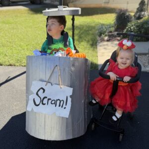Child in an Oscar the Grouch and Elmo costume on wheels