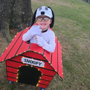 Child in a Snoopy costume on wheels