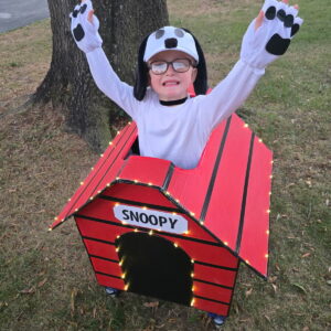 Child in a Snoopy costume on wheels