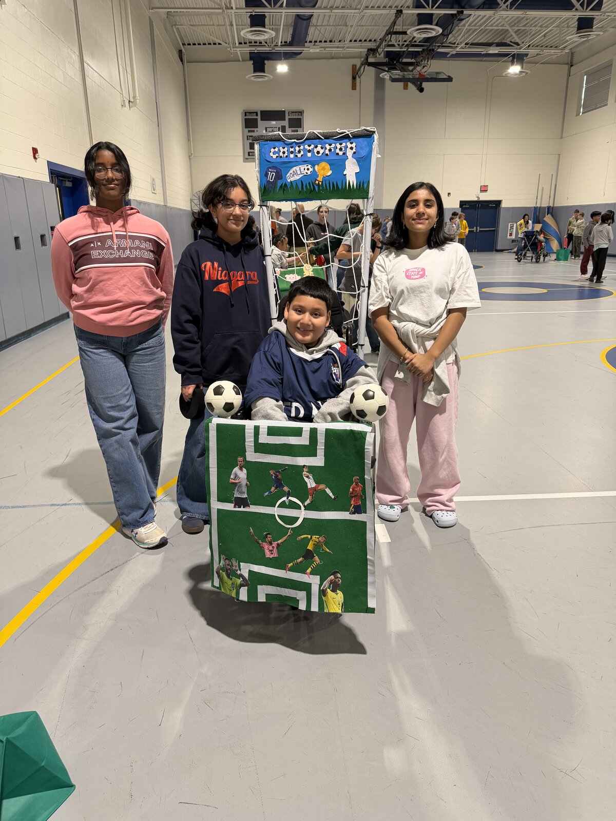 Child in a Soccer Player costume on wheels with the Timberlane Middle School students who built it