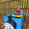 Child in a Thomas the Train costume on wheels