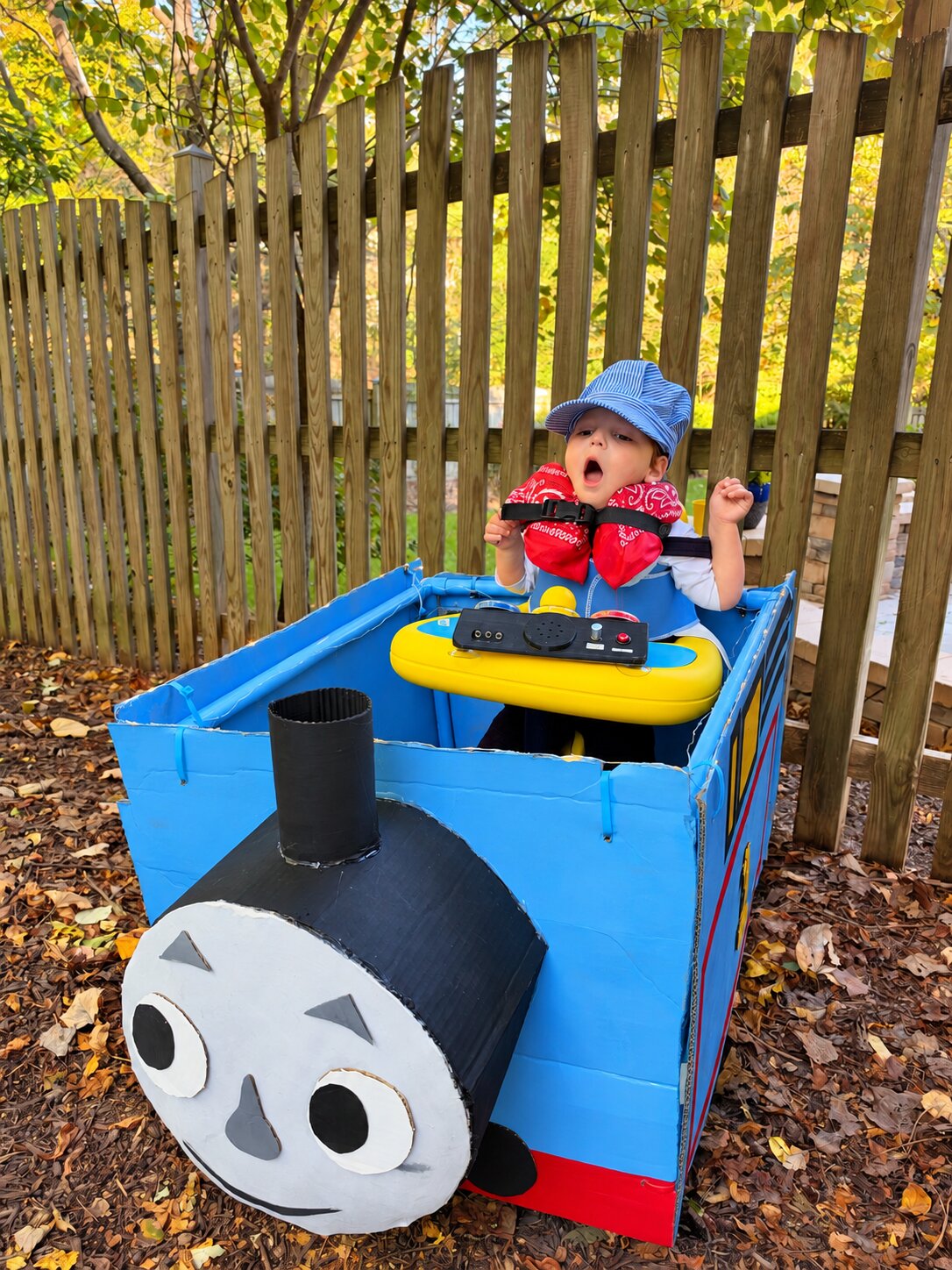 Child in a Thomas the Train costume on wheels