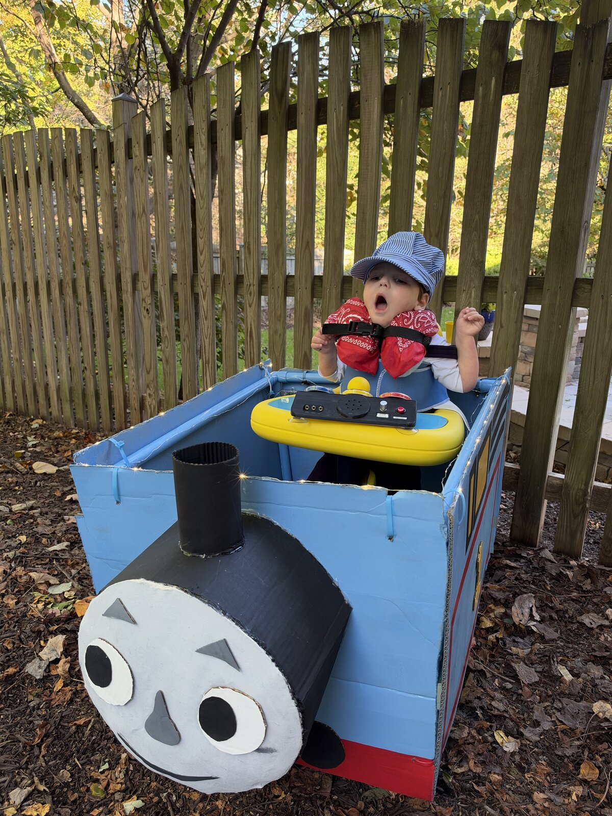 Child in a Thomas the Train costume on wheels