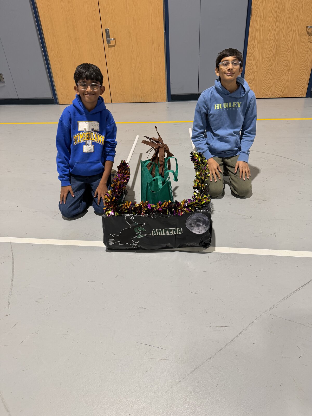 Child in a Witch costume on wheels with the Timberlane Middle School students who built it
