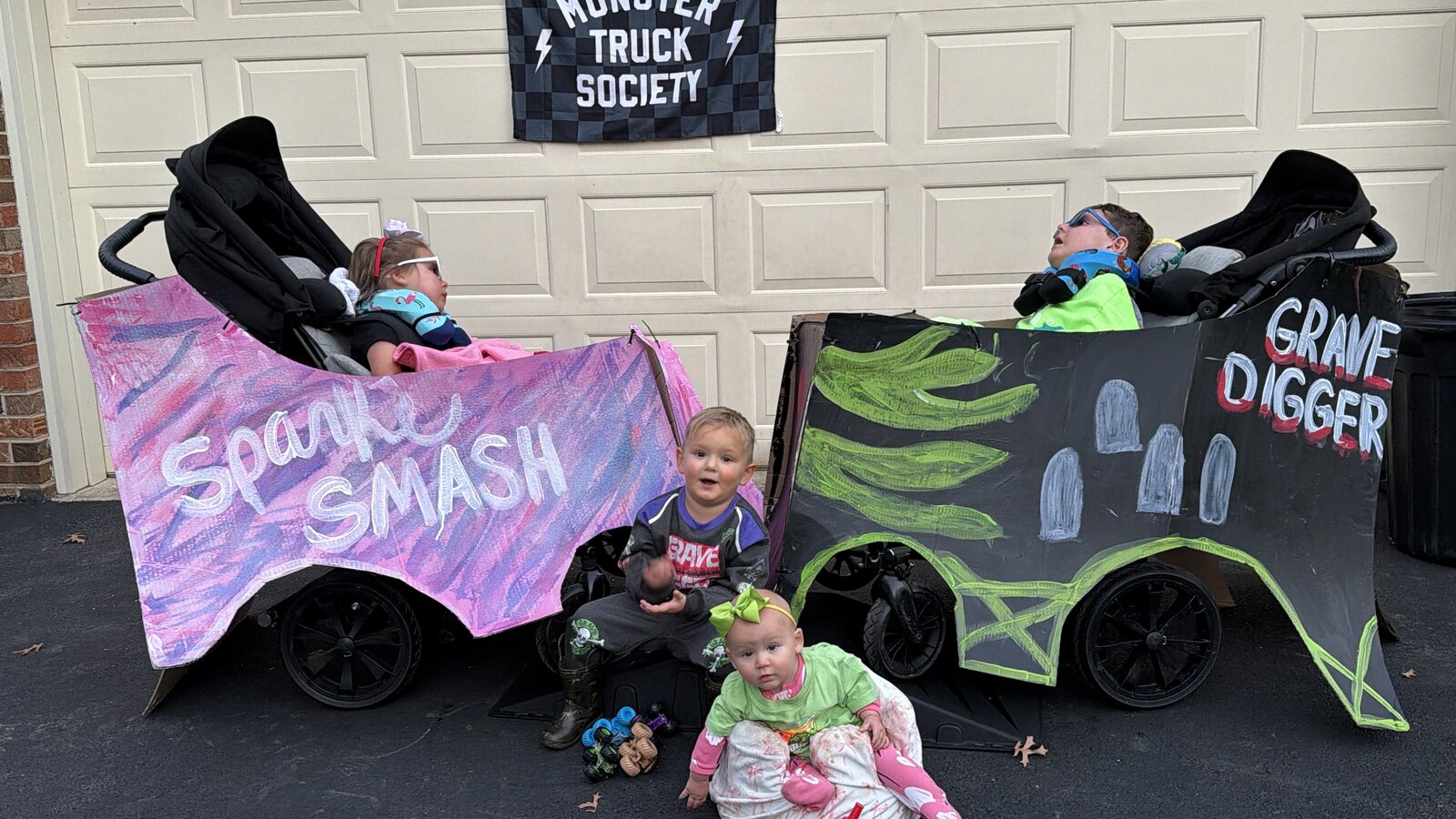 Children in Monster Truck Society costumes on wheels
