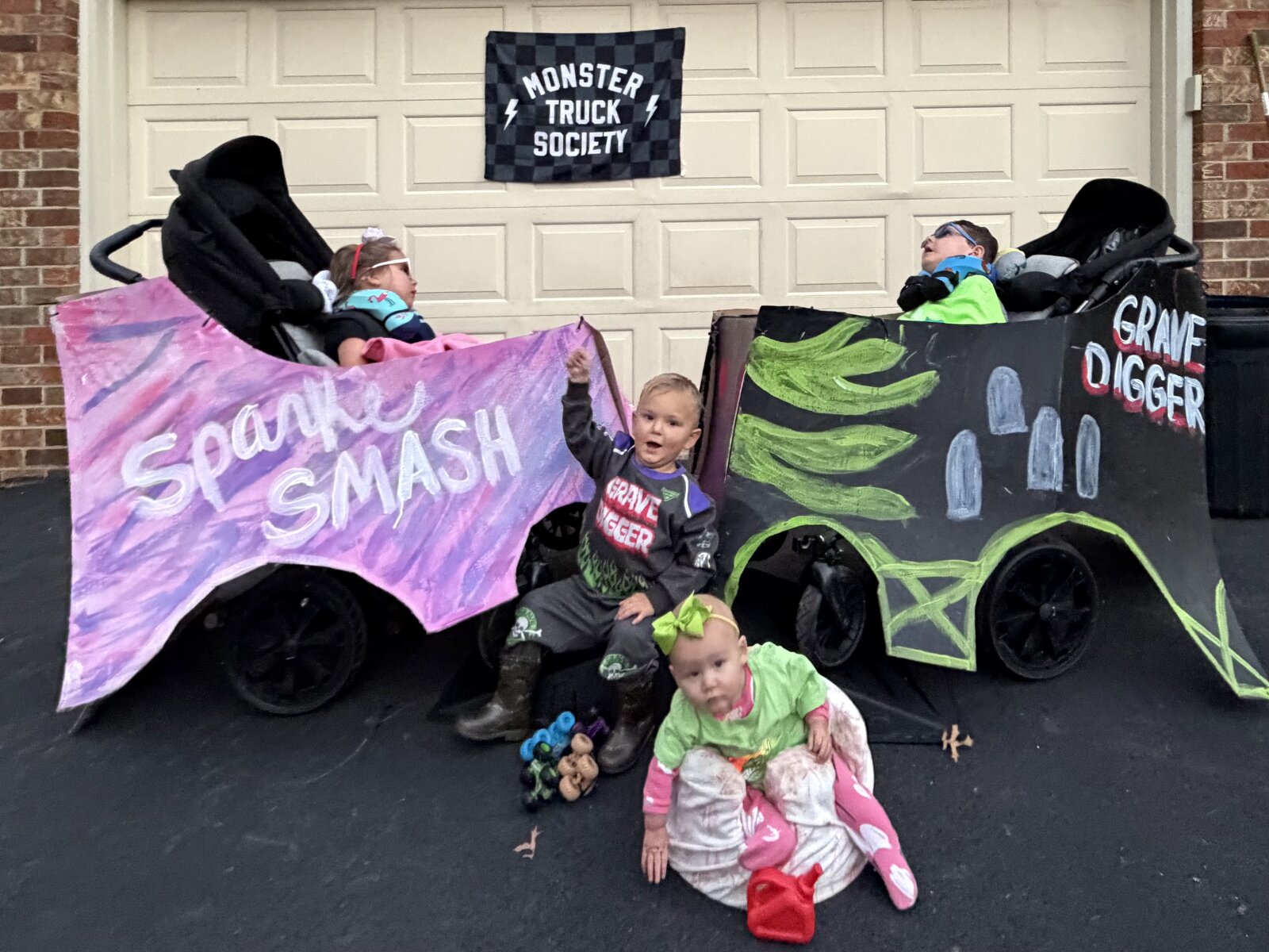 Children in Monster Truck Society costumes on wheels