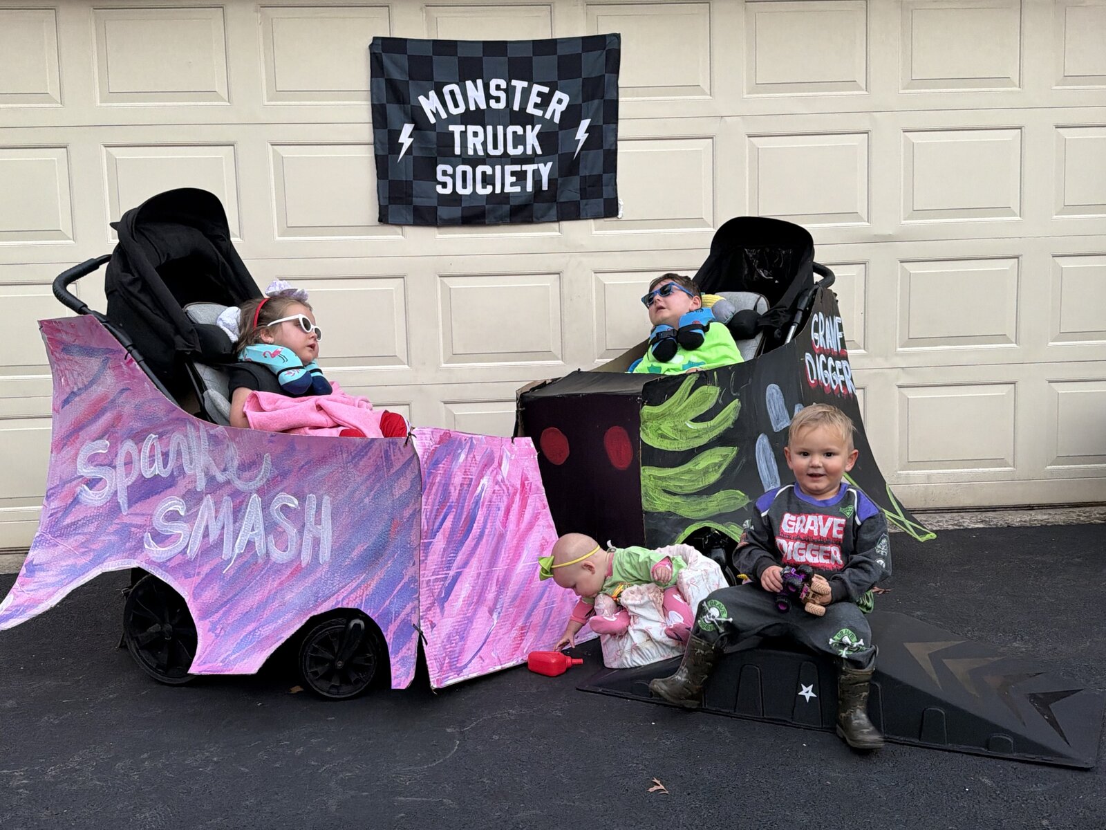 Children in Monster Truck Society costumes on wheels
