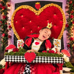 Child in a Queen of Hearts costume on wheels