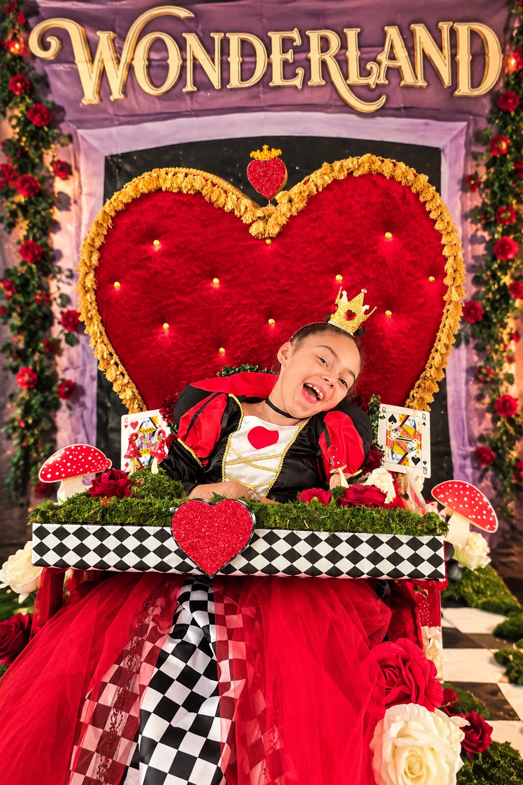 Child in a Queen of Hearts costume on wheels