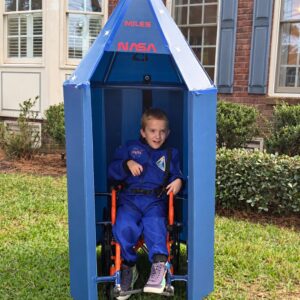 Child in a Dr. Ryland Grace astronaut costume inside a rocket ship on wheels