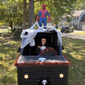 Child in a Punisher ride costume with Spider-Man on wheels